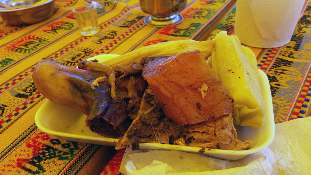 Image of plate of lechon and tamales in Huarocondo.